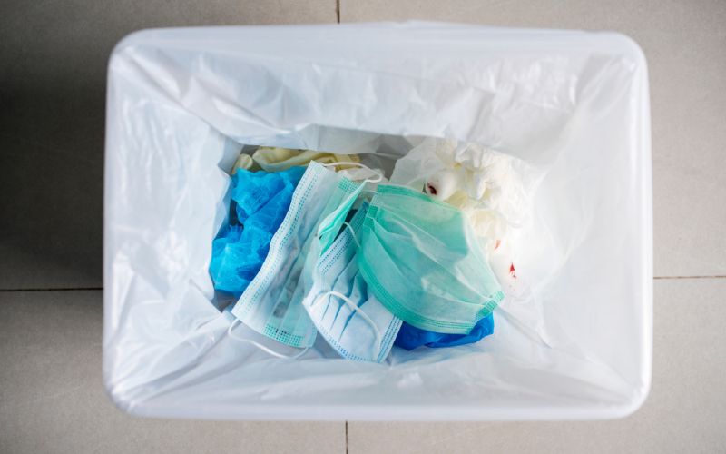 Used face masks in a contaminated waste bin